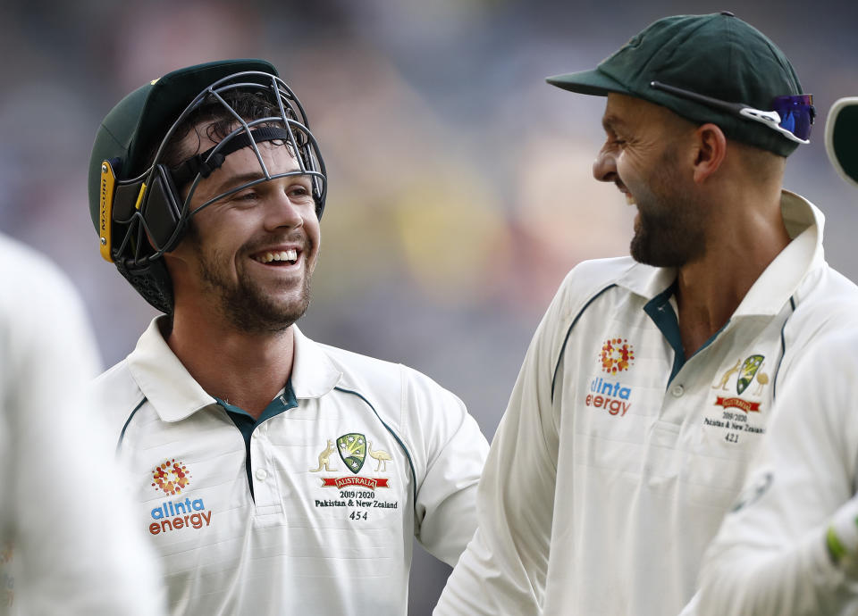 Travis Head and Nathan Lyon laugh and celebrate after combining to take a wicket.