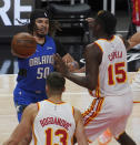 Orlando Magic guard Cole Anthony (50) looks for an opening past Atlanta Hawks guard Bogdan Bogdanovic (13) and center Clint Capela (15) in the first half of an NBA basketball game Thursday, May 13, 2021 in Atlanta. (AP Photo/Tami Chappel)