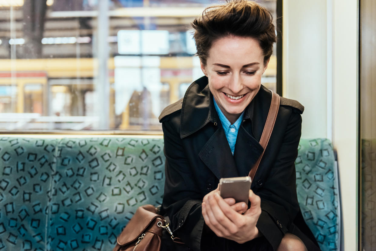 leaveism Mature businesswoman checking Messages on her smart phone while commuting in train