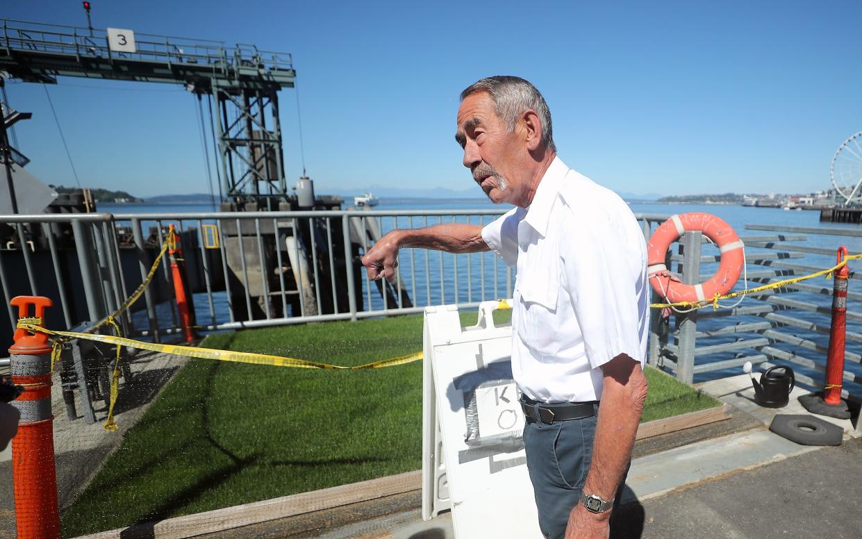 Allen Daniel, a Seattle resident and traffic attendant for Washington State Ferries, talks about a grass area that he attends to at Colman Dock in Seattle on Wednesday, Aug. 2, 2023. Daniel created the grass oasis for dogs to relieve themselves on, but the space isn't open just yet.