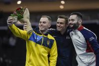 Second place winner Oleg Verniaiev of Ukraine takes a selfie with first place winner Sam Mikulak of the United States and third place winner James Hall of Great Britain after the American Cup gymnastics competition Saturday, March 7, 2020, in Milwaukee. (AP Photo/Morry Gash)