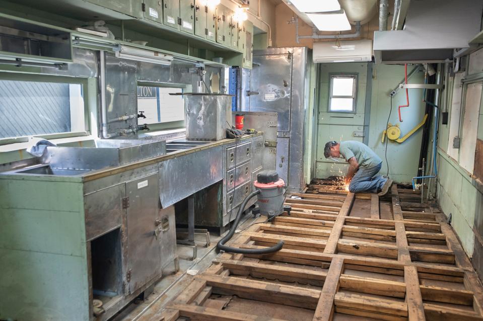 Welder Dean Motis works on restoring the floor in the dining car&#39;s kitchen at the West Florida Railroad Museum in Milton on Friday.