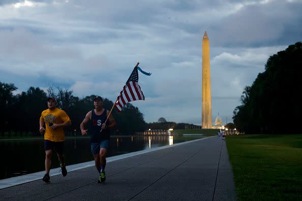 WASHINGTON, DC - SEPTEMBER 11: A jogger carries the American flag as they run along the National Mall on September 11, 2023 in Washington, DC. U.S. Leaders are observing the 22nd anniversary of the 9/11 terrorist attacks around the country with first lady Jill Biden attending a ceremony at the National 9/11 Pentagon Memorial and U.S. President Joe Biden speaking to service members in Alaska. (Photo by Anna Moneymaker/Getty Images)