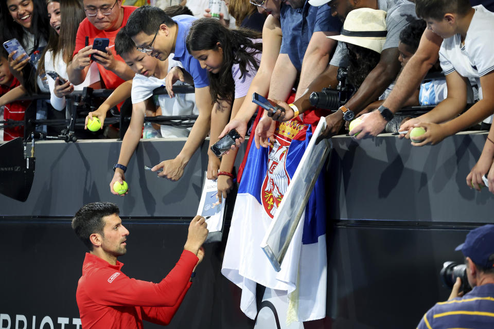 Serbia's Novak Djokovic Signs autographs after defeating Russia's Daniil Medvedev in their semi final match at the Adelaide International Tennis tournament in Adelaide, Australia, Saturday, Jan. 7, 2023. (AP Photo/Kelly Barnes)