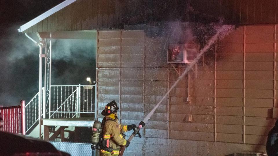 Firefighters work to extinguish a fire at a home on Quincy Street in Kennewick. The blaze left a man in critical condition.