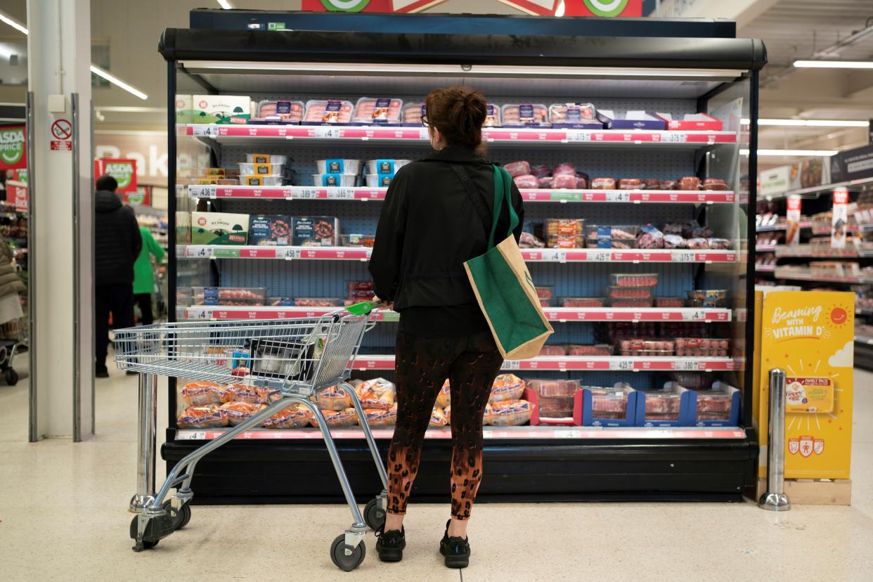 People shop in a supermarket in Huyton, Britain as cost of living squeeze continues