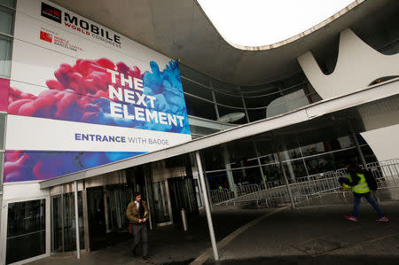 People walk past the main entrance of the Mobile World Congress in Barcelona, Spain February 24, 2017. REUTERS/Albert Gea