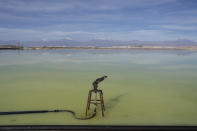 Brine evaporates from pools at the lithium extraction plant facilities of the SQM Lithium company near Peine, Chile, Tuesday, April 18, 2023. In 2016, an investigation found SQM extracted more groundwater than legally permitted for consecutive years, something authorities said “put the stability of the ecosystem in extreme risk.” SQM later accused its neighbor of doing the same. (AP Photo/Rodrigo Abd)