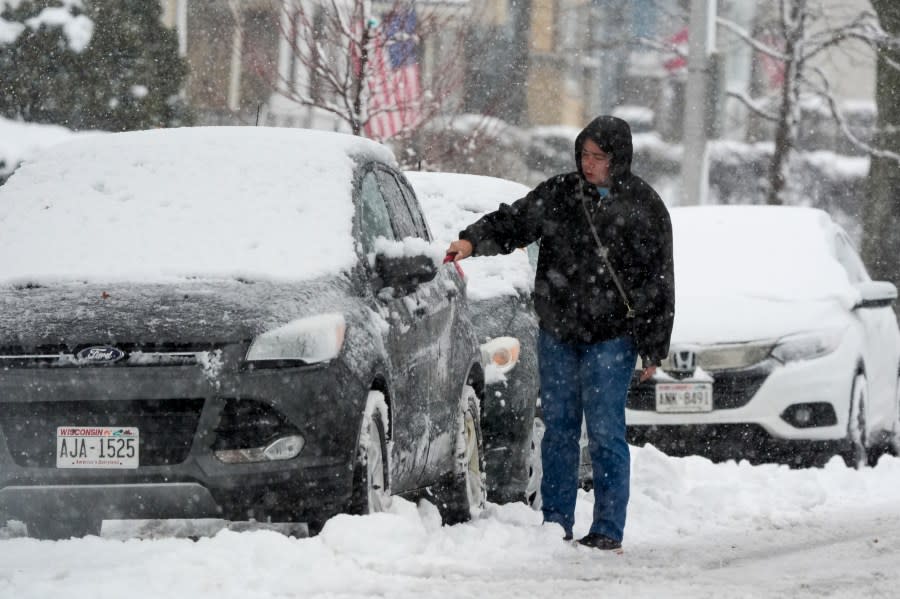 A driver clears snow from his car as a winter storm arrives Friday, Jan. 12, 2024, in Milwaukee. (AP Photo/Morry Gash)