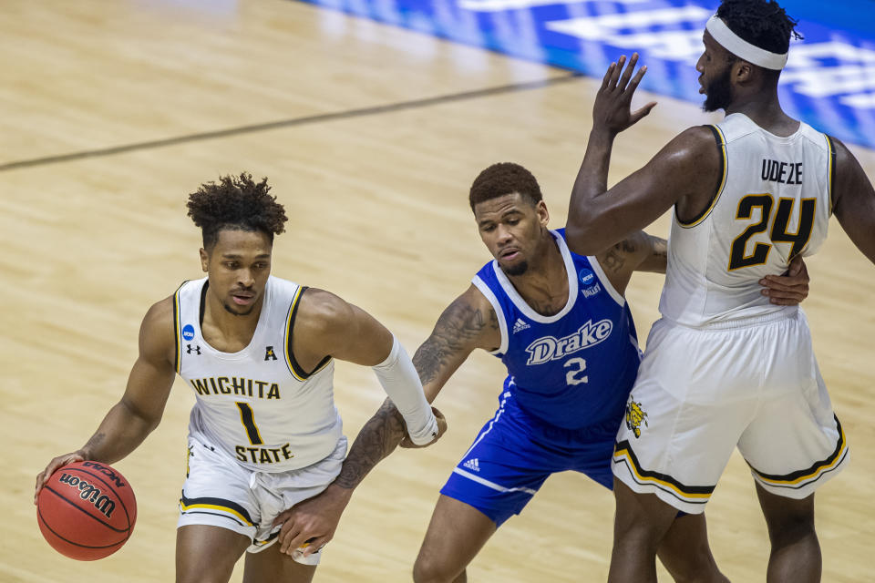 Wichita State's Tyson Etienne (1) uses a screen from teammate Morris Udeze (24) to move past Drake's Tremell Murphy (2) during the first half of a First Four game in the NCAA men's college basketball tournament Thursday, March 18, 2021, at Mackey Arena in West Lafayette, Ind. (AP Photo/Robert Franklin)