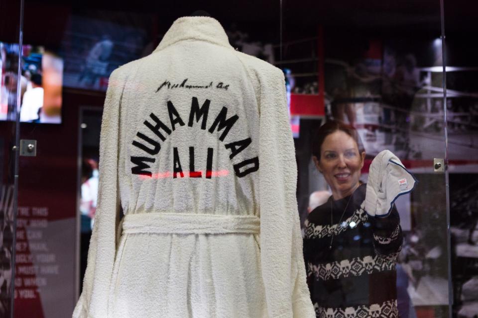 LONDON, ENGLAND - MARCH 03 :  A woman cleans the glass cabinet containing a Muhammad Ali cotton robe  embroidered on the back with 'Muhammad Ali' during a press call at 'I Am The Greatest: Muhammad Ali at The O2, on March 3, 2016 in London, England. The exhibition explores Muhammad Alis life and rise from humble beginnings in Kentucky where he was known as The Louisville Lip, to becoming the three times heavyweight champion of the World and known as The Greatest. The exhibition opens Friday March 4, 2016 and runs to August 31, 2016. (Photo by Vickie Flores/Anadolu Agency/Getty Images)
