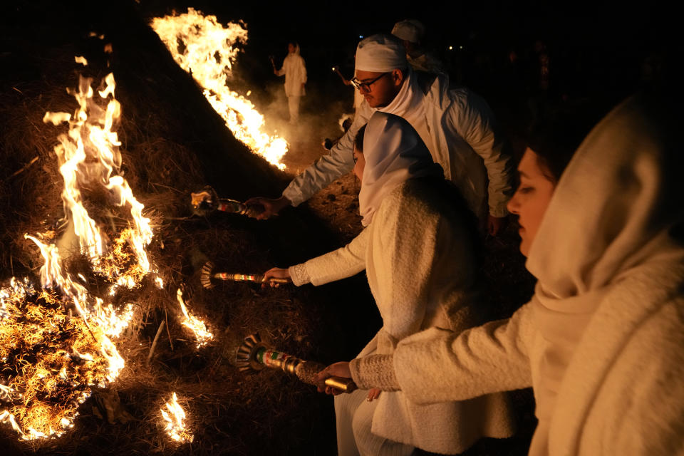 Iranian Zoroastrian youth set fire to a prepared pile of wood in a ceremony celebrating their ancient mid-winter Sadeh festival in the outskirts of Tehran, Iran, Tuesday, Jan. 30, 2024. Hundreds of Zoroastrian minorities gathered after sunset to mark their ancient feast, creation of fire, dating back to Iran's pre-Islamic past. (AP Photo/Vahid Salemi)
