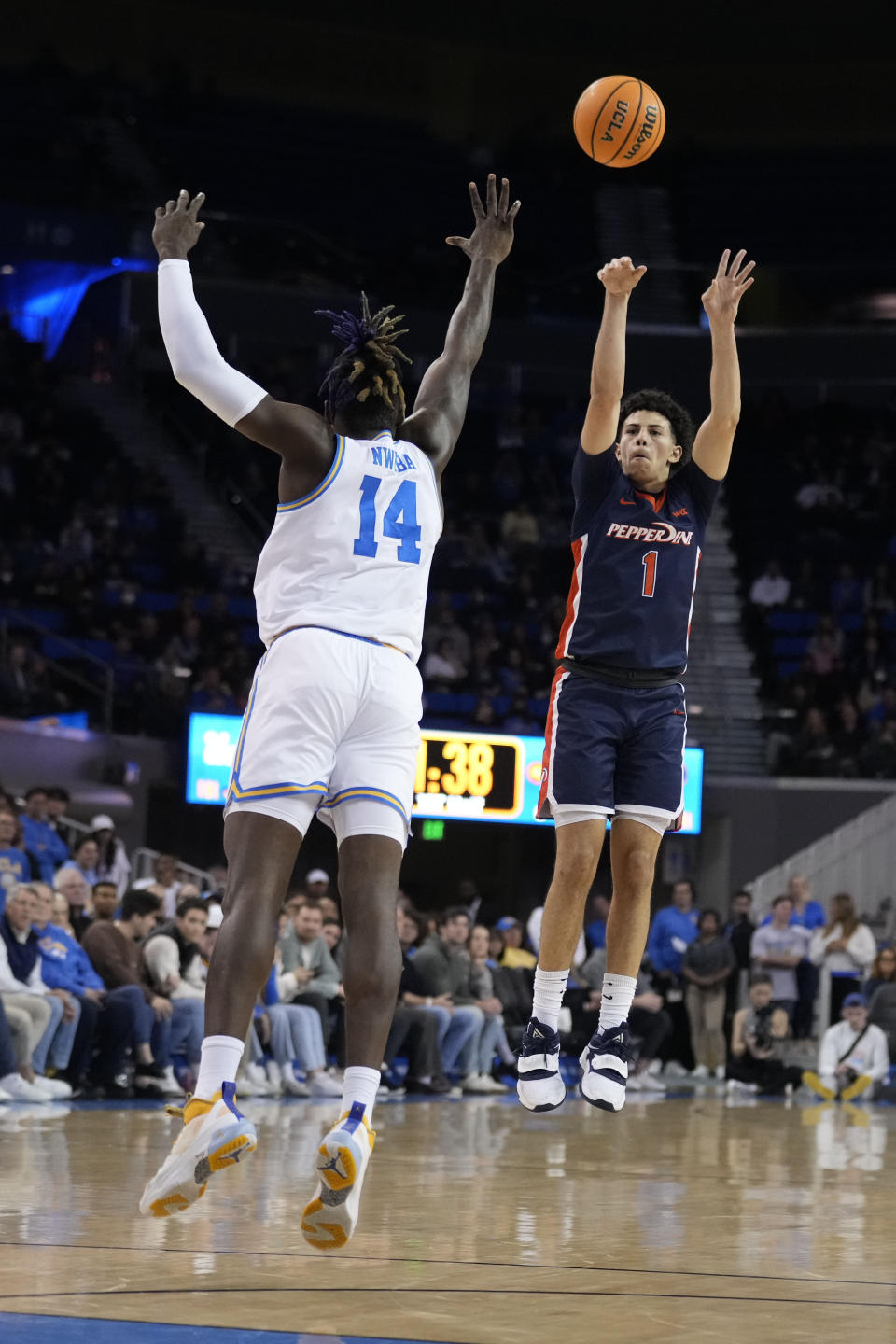 Pepperdine guard Mike Mitchell Jr. (1) shoots over UCLA forward Kenneth Nwuba (14) during the first half of an NCAA college basketball game Wednesday, Nov. 23, 2022, in Los Angeles. (AP Photo/Marcio Jose Sanchez)