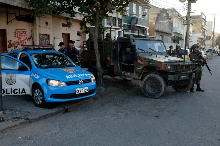 Brazilian marines (L) and police patrol the Mare favela complex, an area prone to gang warfare and drug trafficking, in Rio de Janeiro, on June 30, 2015