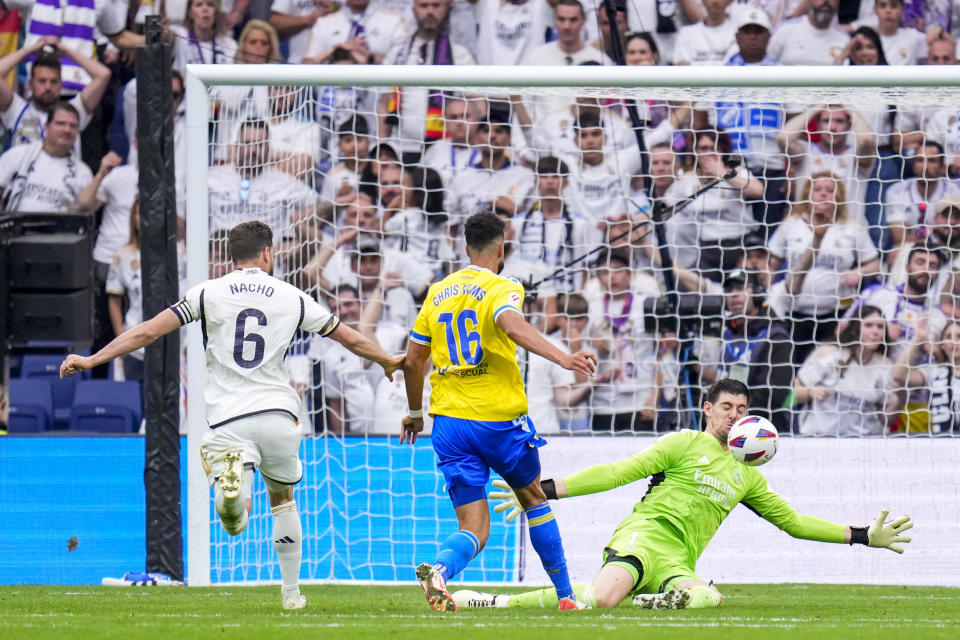 Real Madrid's goalkeeper Thibaut Courtois saves a ball during the the Spanish La Liga soccer match between Real Madrid and Cadiz at the Santiago Bernabeu stadium in Madrid, Spain, Saturday, May 4, 2024. (AP Photo/Manu Fernandez)