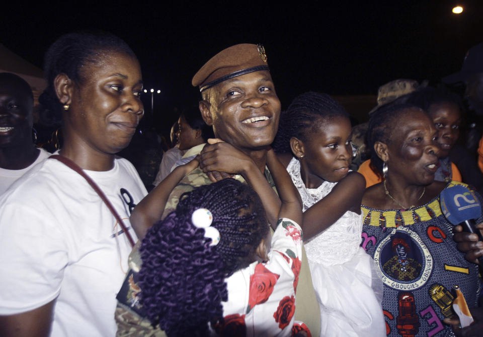 One of the soldiers from Ivory Coast who were convicted of undermining Mali's state security and conspiracy against the government and were pardoned by Mali's military junta leader react with family members as they arrive in Abidjan, Ivory Coast, late Saturday Jan. 7, 2023. In a statement Friday, the junta's spokesman said junta leader, Col. Assimi Goita, granted the pardon and “demonstrates once again his commitment to peace, dialogue, pan-Africanism, and the preservation of fraternal and secular relations with the countries of the region, in particular those between Mali and Ivory Coast." (AP Photo/ Diomande Ble Blonde)