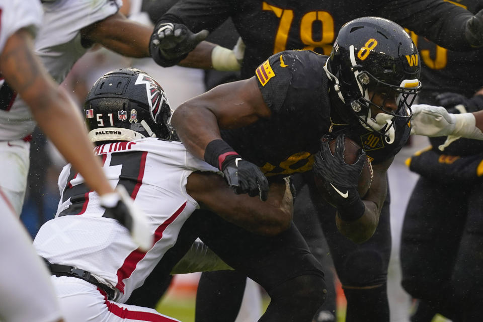 Washington Commanders running back Brian Robinson Jr. (8) carries the ball for a first down against Atlanta Falcons linebacker DeAngelo Malone (51) during the second half of an NFL football game, Sunday, Nov. 27, 2022, in Landover, Md. (AP Photo/Patrick Semansky)