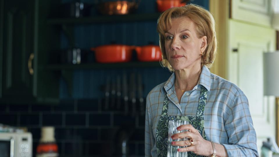Juliet Stevenson in a shirt and apron holding a glass as Matilda Anchor-Ferrers in Wolf.