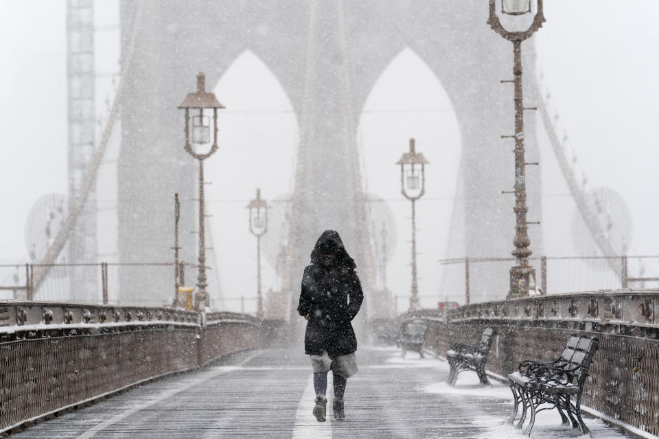 A woman walks on the Brooklyn Bridge, Monday, Feb. 1, 2021 in New York. A winter snowstorm walloped the Eastern U.S. on Monday. (AP Photo/Mark Lennihan)