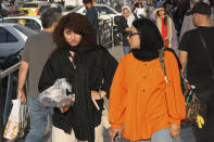 A woman walks around Tajrish commercial district without wearing her mandatory Islamic headscarf in northern Tehran, Iran, Saturday, April 29, 2023. More women are choosing not to wear the mandatory headscarf, or the hijab, publicly in Iran. Such open defiance of the law follows months of protests over the September death of 22-year-old Mahsa Amini while in the custody of the country's morality police, for wearing her hijab too loosely. (AP Photo/Vahid Salemi)