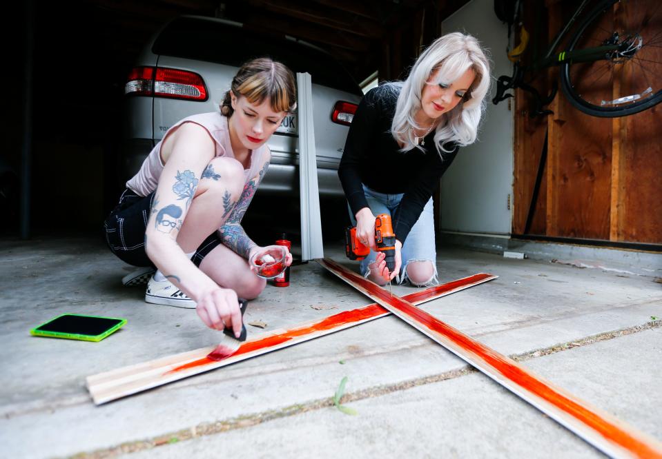 AJ Jenkins (left) and Heidi Mae Herrington build props for a recreation of a movie poster for the slasher-horror film "Pearl" on Thursday, May 4, 2023.