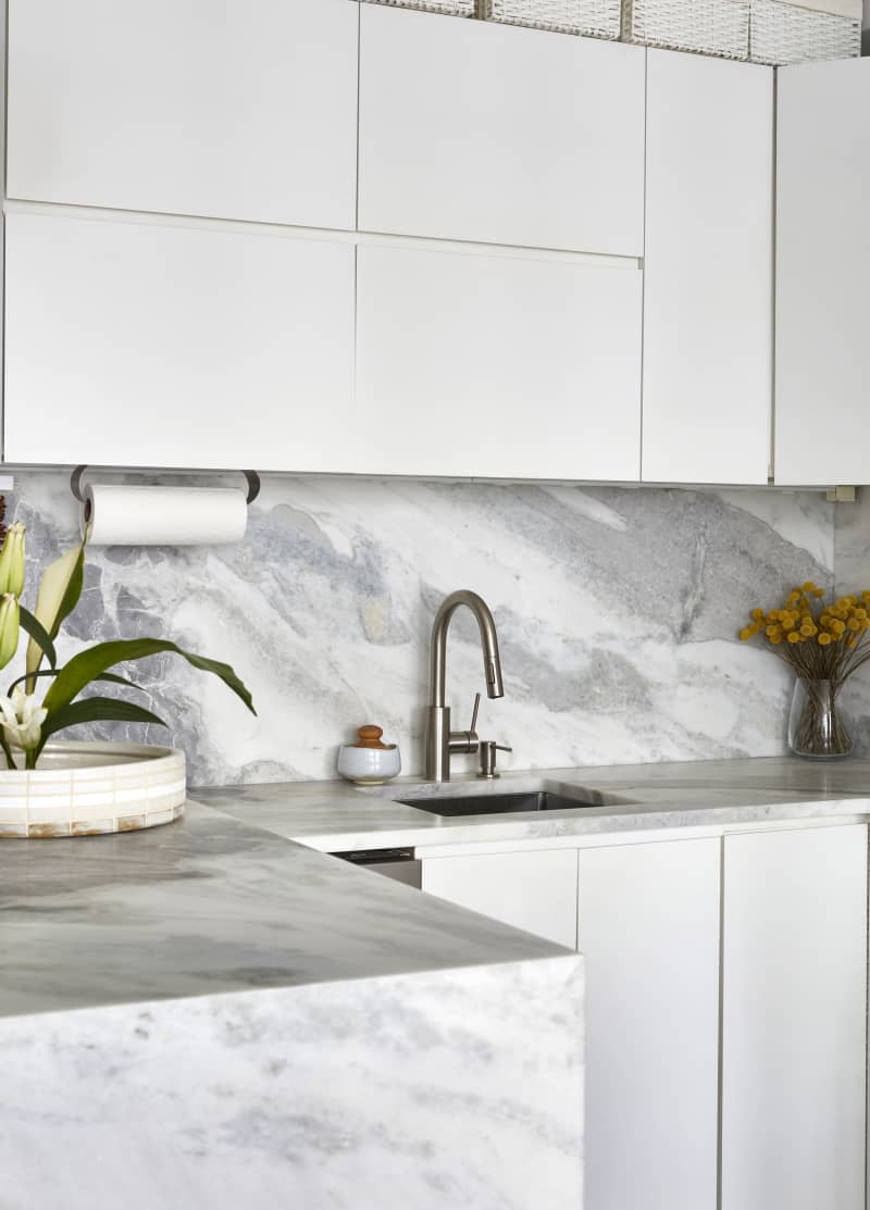 Kitchen marble counters/backsplash sink detail with white cabinets