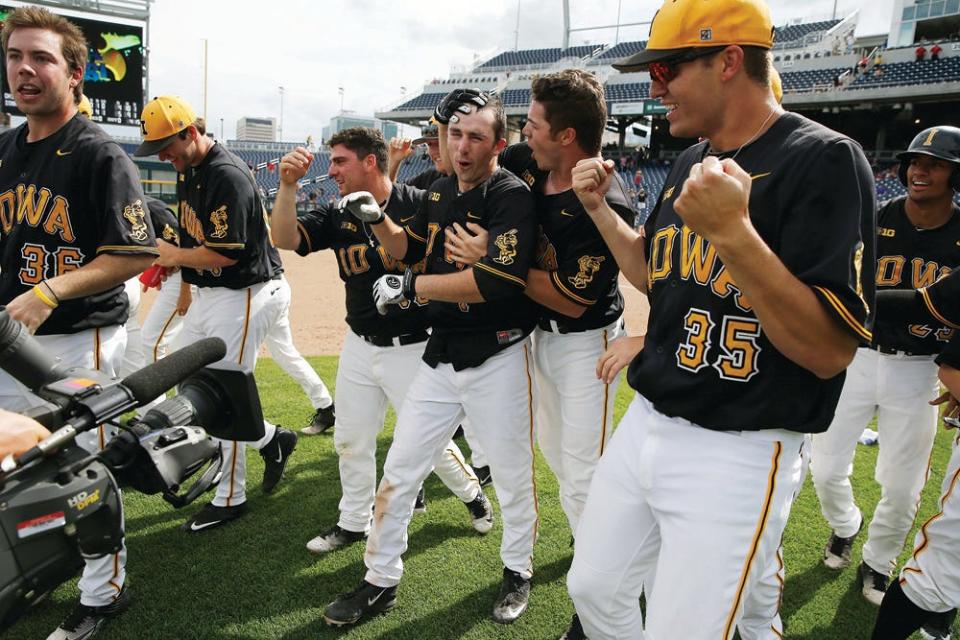 Iowa Hawkeyes catcher Austin Guzzo (20) hugs infielder Mason McCoy (1) as they celebrate with win over the Ohio State Buckeyes May 27 at TD Ameritrade Park in Omaha, Neb.