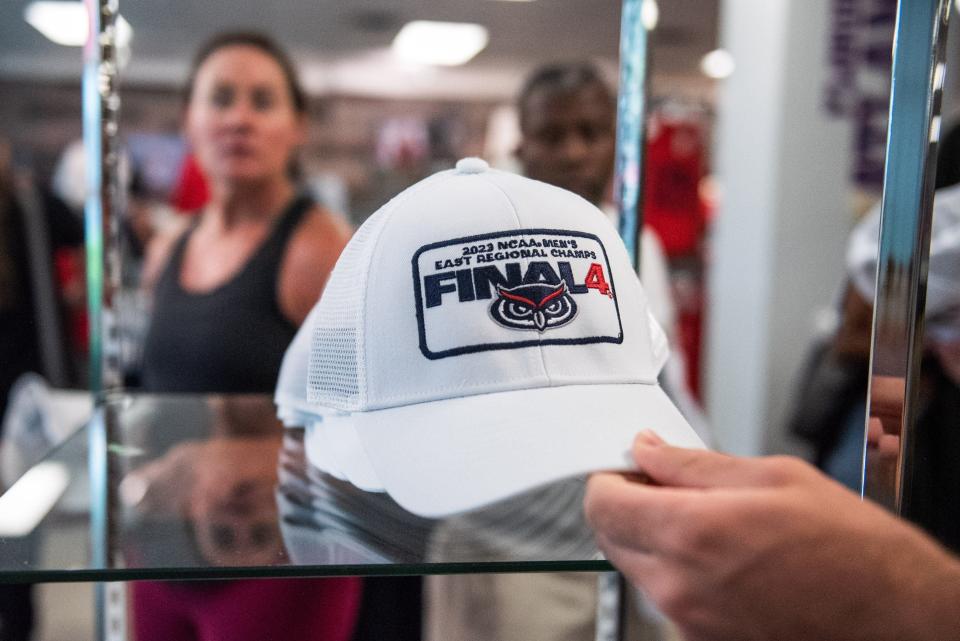 A customer at the FAU Campus Store grasps a cap referencing the Florida Atlantic men's basketball team's appearance at the NCAA Tournament Final Four from a shelf on Wednesday, March 29, 2023, in Boca Raton, FL. FAU Campus store staff said the Tuesday afternoon shipment of merchandise celebrating the men's basketball team's appearance at the NCAA Tournament Final Four sold out the same day it arrived.