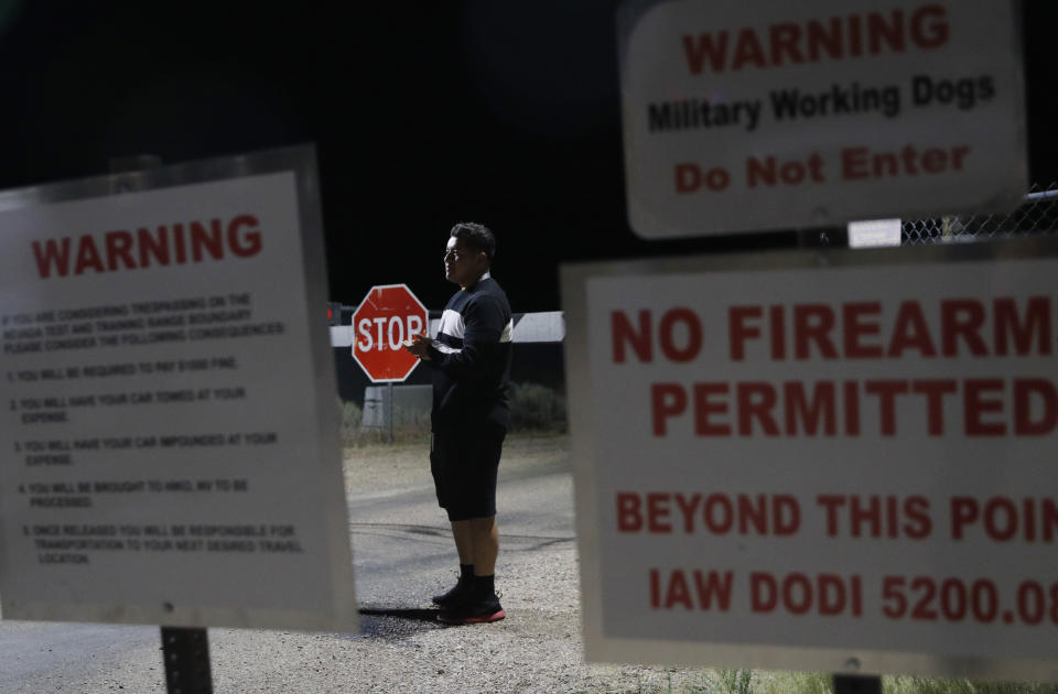 A man stands at an entrance to the Nevada Test and Training Range near Area 51 Friday, Sept. 20, 2019, near Rachel, Nev. People gathered at the gate inspired by the "Storm Area 51" internet hoax. (AP Photo/John Locher)