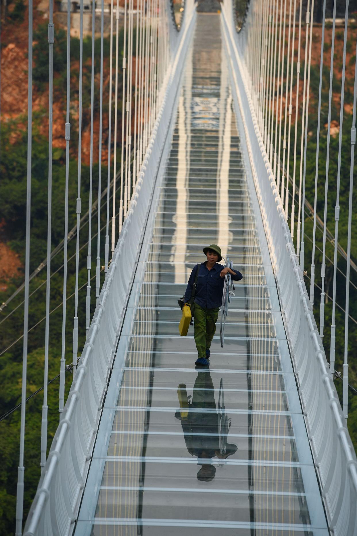 a person stands on the Bach Long glass bridge in the Moc Chau district in Vietnam's Son La province
