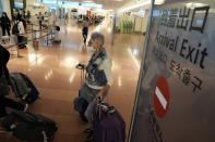 One of foreign travelers walks upon arrival at the Haneda Airport Tuesday, Oct. 11, 2022, in Tokyo. Japan's strict border restrictions are eased, allowing tourists to easily enter for the first time since the start of the COVID-19 pandemic. Independent tourists are again welcomed, not just those traveling with authorized groups. (AP Photo/Eugene Hoshiko)