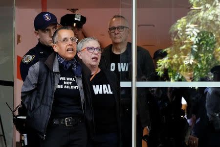 New York City Police officers (NYPD) escort protestors after making arrests for demonstrating in Trump Tower in New York City, U.S., April 13, 2017. REUTERS/Brendan McDermid