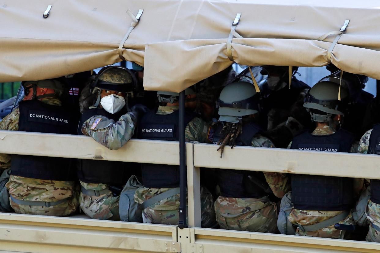 A member of the District of Columbia National Guard looks out from a vehicle driving by the White House: AP