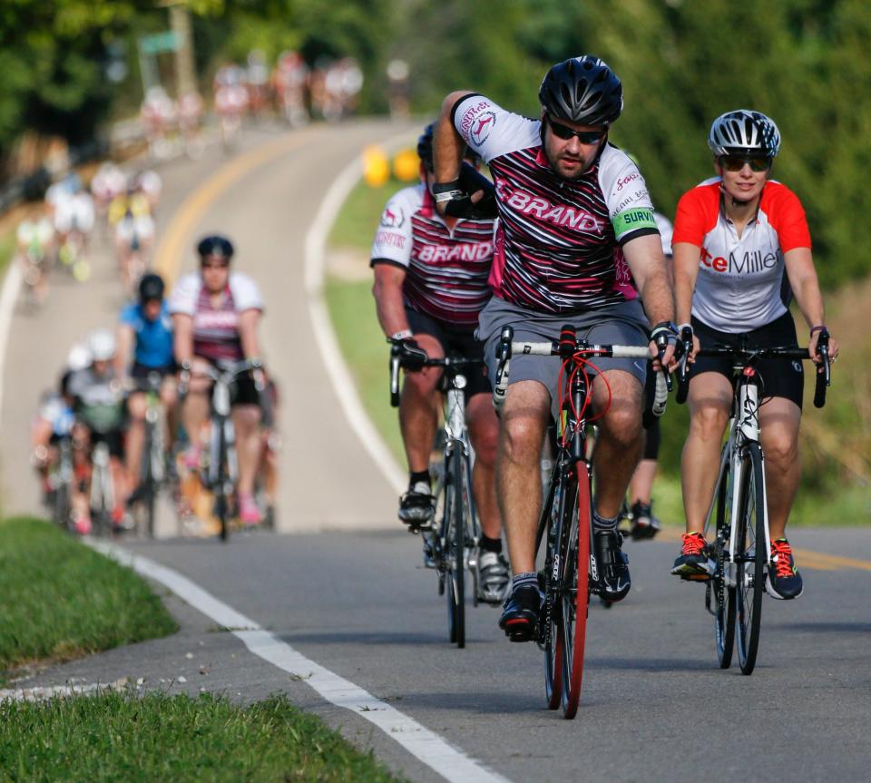 John Wheeler, of Westerville, Ohio and a cancer survivor, puts away his water bottle as he pedals up Licking County Road 539 on his way into Granville during Pelotonia 2017.