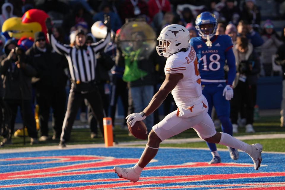 Texas running back Bijan Robinson scores the second of his four touchdowns in Saturday's 55-14 win over Kansas in Lawrence. Robinson had a career game, finishing with 243 yards and the four scores, and the win kept Texas in the hunt for a spot in the Big 12 championship game.