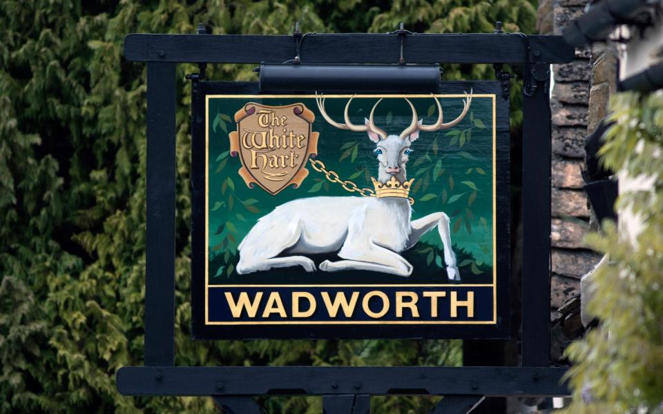 Sign of the times: the White Hart, a Wadworth Brewery pub, in Castle Combe, Wiltshire - alamy