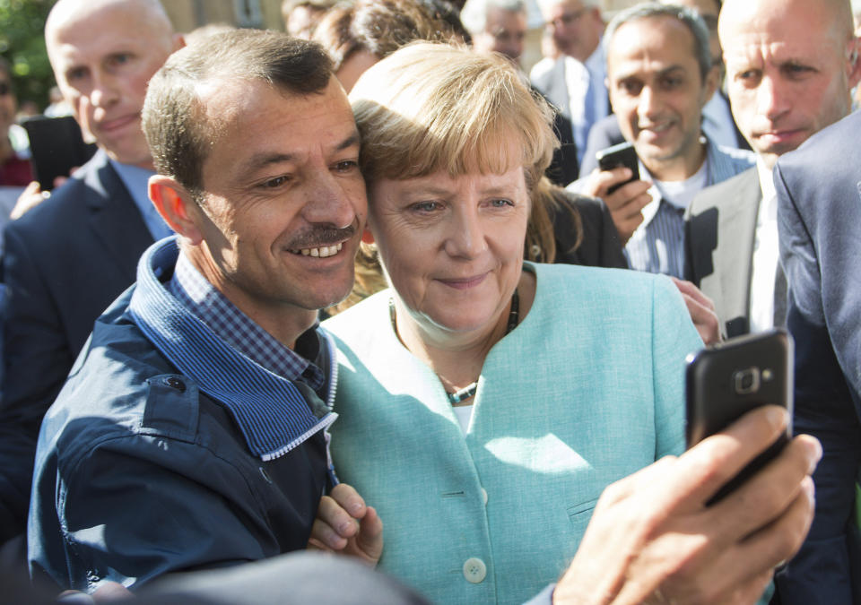 FILE - In this Sept. 9, 2015 file photo German chancellor Angela Merkel poses for a selfie with a refugee in a facility for arriving refugees in Berlin. The U.N. refugee agency says it's giving its highest award to former German Chancellor Angela Merkel for her efforts to bring in more than 1 million refugees — mostly from Syria — into Germany, despite some pockets of criticism at both home and abroad. (Bernd von Jutrczenka/dpa via AP, File)