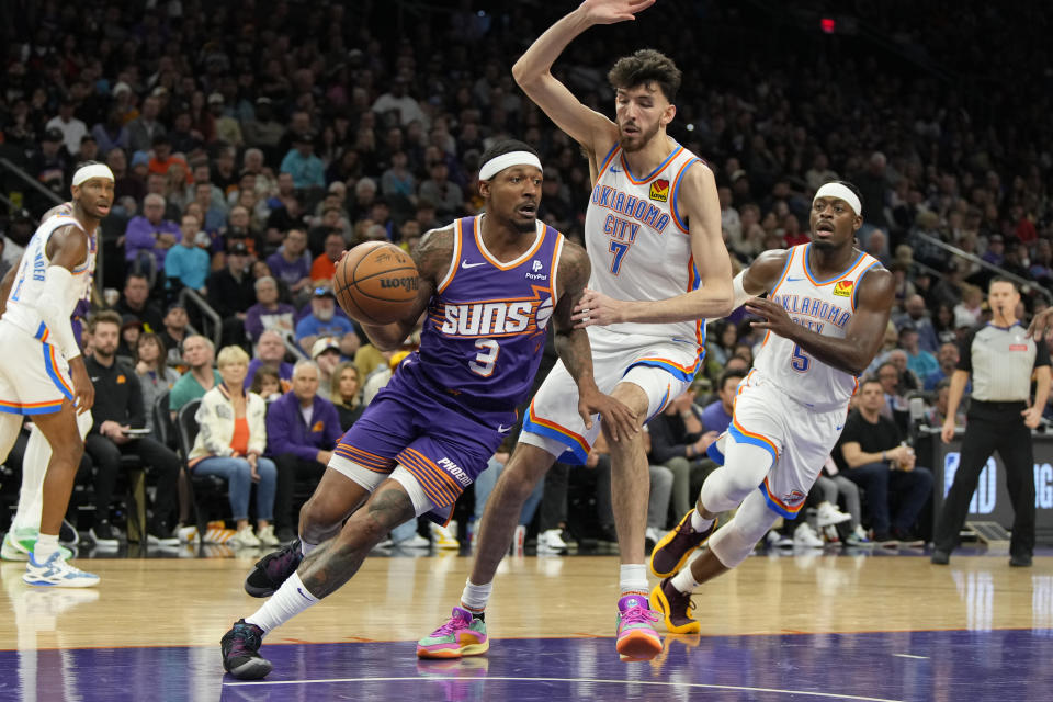 Phoenix Suns guard Bradley Beal (3) drives past Oklahoma City Thunder forward Chet Holmgren (7) and guard Luguentz Dort (5) during the second half of an NBA basketball game, Sunday, March 3, 2024, in Phoenix. (AP Photo/Rick Scuteri)