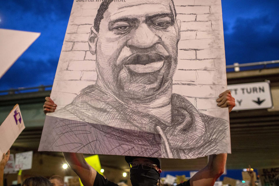 A demonstrator holds a drawing depicting George Floyd in Albuquerque, N.M., Sunday, May 31, 2020. Floyd was a black man who died in police custody in Minneapolis on May 25. (AP Photo/Andres Leighton)