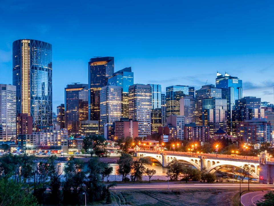 Calgary skyline at night with Bow River and Centre Street Bridge.