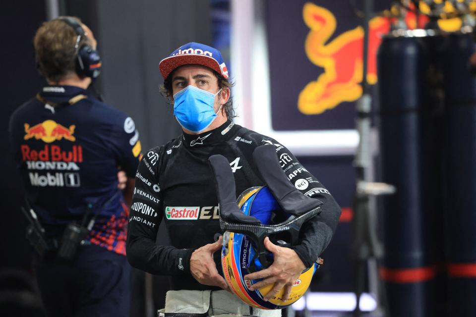 Fernando Alonso (pictured) walks in the pits during the qualifying session.