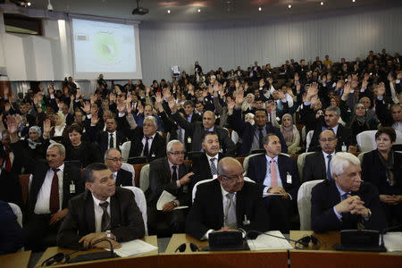 Algerian lawmakers raise their hands as they vote for the constitutional reforms in Algiers, Algeria February 7, 2016. REUTERS/Ramzi Boudina