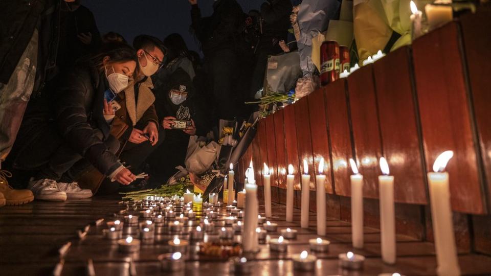 Manifestantes encendiendo velas y dejando cigarrillos encendidos en una conmemoración.