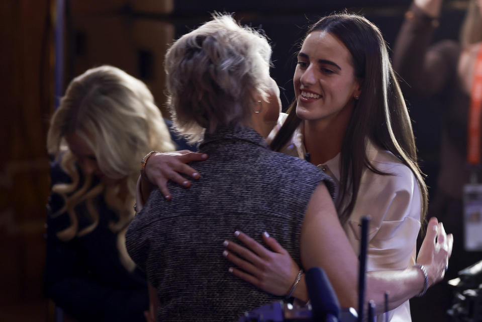 CORRECTS TO CAITLIN CLARK NOT CAITLYN CLARK - Iowa's Caitlin Clark, right, hugs Iowa head coach Lisa Bluder after being selected first overall by the Indiana Fever during the first round of the WNBA basketball draft, Monday, April 15, 2024, in New York. (AP Photo/Adam Hunger)