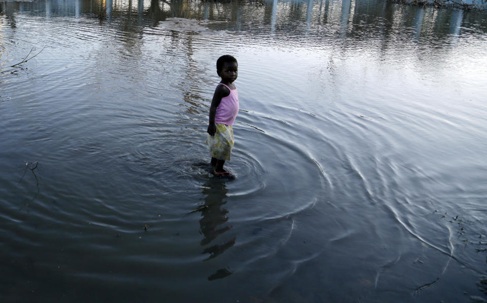 A young girl plays in the water outside a school in Beira, Mozambique, Monday, March 25, 2019. Cyclone Idai's death toll has risen above 750 in the three southern African countries hit 10 days ago by the storm, as workers rush to restore electricity, water and try to prevent outbreak of cholera. (AP Photo/Themba Hadebe)