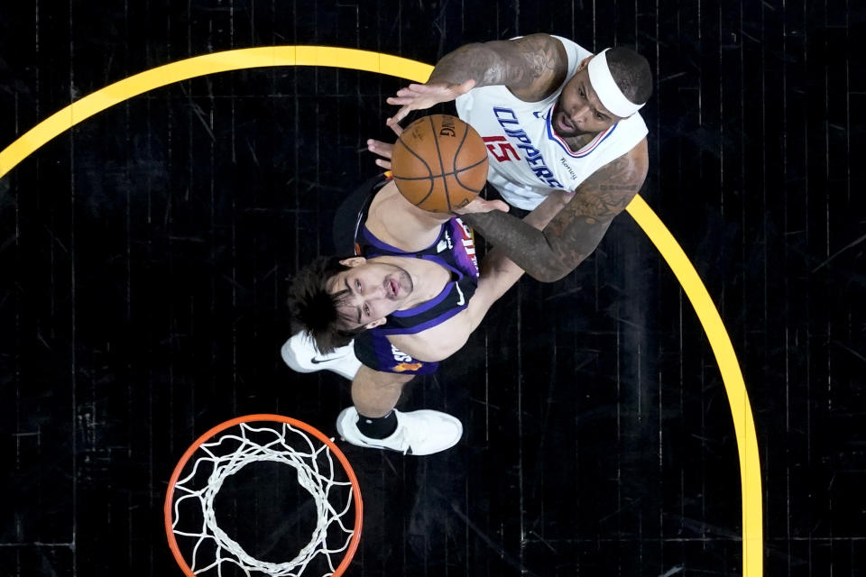 Los Angeles Clippers center DeMarcus Cousins (15) shoots over Phoenix Suns forward Dario Saric during the first half of game 5 of the NBA basketball Western Conference Finals, Monday, June 28, 2021, in Phoenix. (AP Photo/Matt York)
