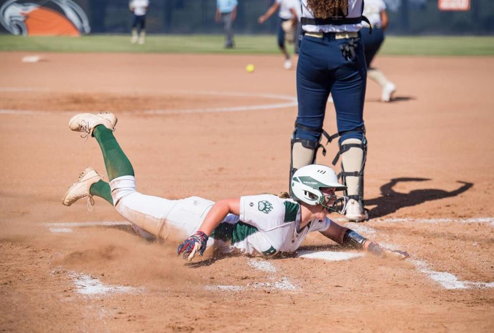 Ponderosa Bruins baserunner Brynn Escobar (11) slides in to score the game’s lone run on a hit from sister Ellie Escobar during the second inning against the Central Catholic Raiders at the CIF Sac-Joaquin Section Division III high school softball championship game Saturday, May 27, 2023, at Cosumnes River College.