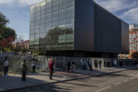 People queue for a rapid antigen test for COVID-19 in the southern neighbourhood of Vallecas in Madrid, Spain, Thursday, Oct. 1, 2020. Madrid and its suburbs are preparing to enter a soft lockdown that restricts trips and out of the Spanish capital following a weeks-long political turf fight over Europe's latest infection hot spot. (AP Photo/Bernat Armangue)