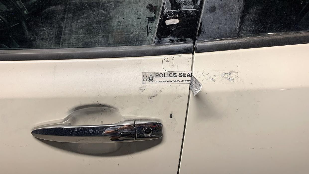 police seal is stuck on a door and fingerprinting dust marks a recovered stolen car