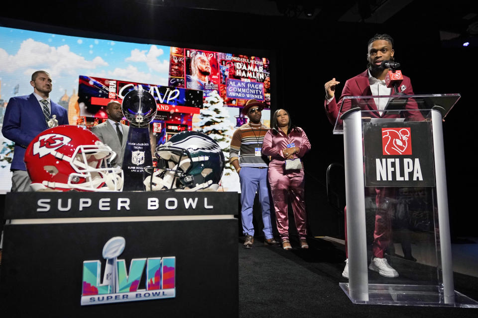 Buffalo Bills' Damar Hamlin speaks after being introduced as the winner of the Alan Page Community Award during a news conference ahead of the Super Bowl 57 NFL football game, Wednesday, Feb. 8, 2023, in Phoenix. At center looking on are Damar Hamlin's parents Mario and Nina Hamlin. At far left is NFLPA President JC Tretter.(AP Photo/Mike Stewart)